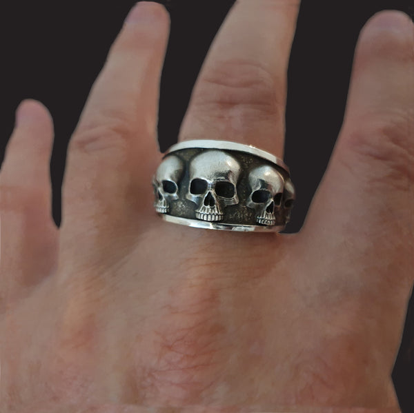 Five skull flared band ring.
