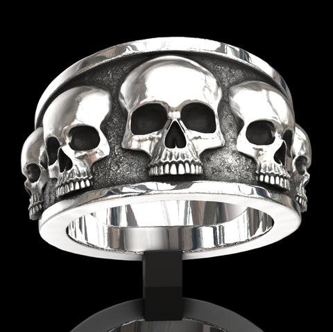Five skull flared band ring.