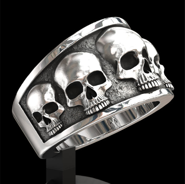 Five skull flared band ring.